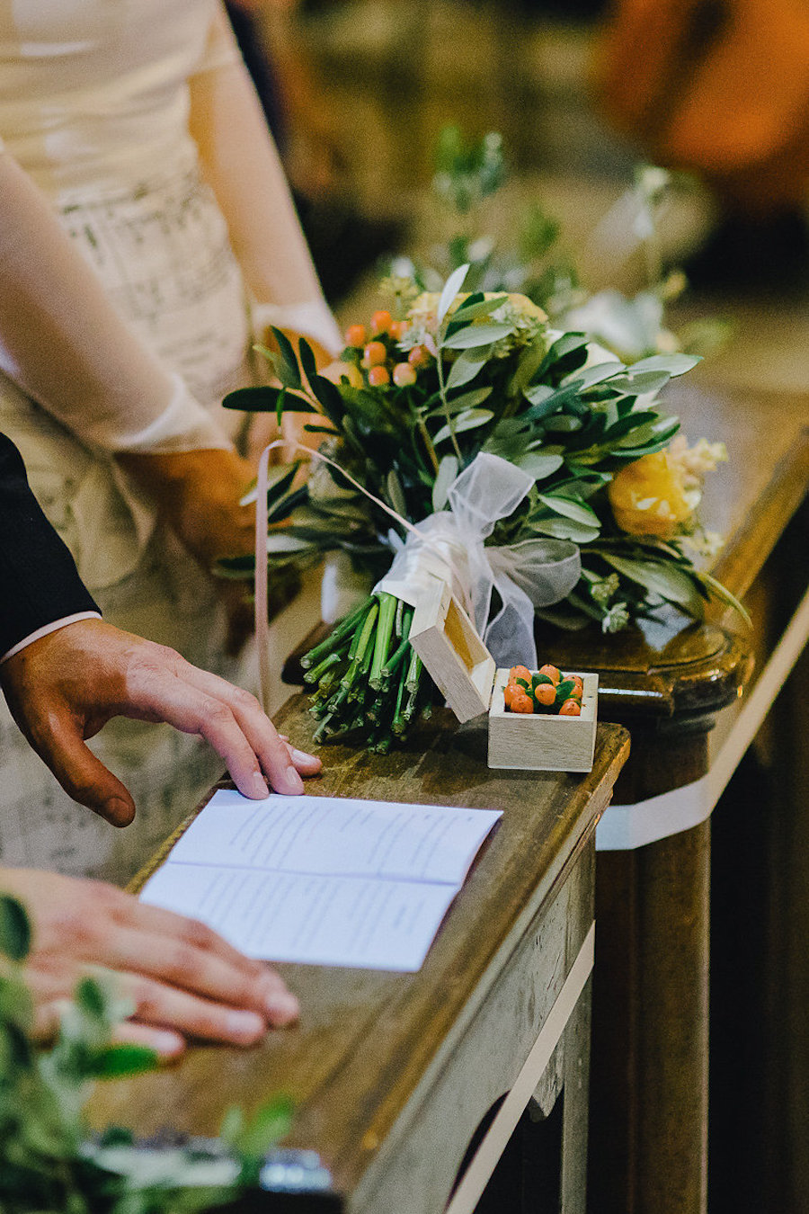 bouquet giallo, verde e arancione e scatola portafedi con bacche